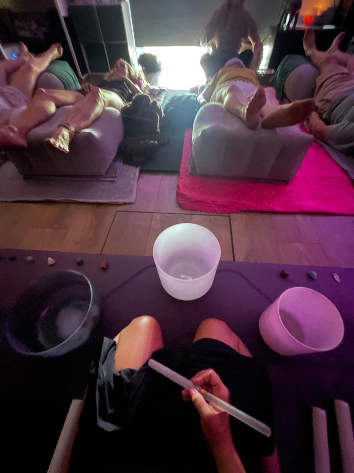 A small group gathered around sound bowls